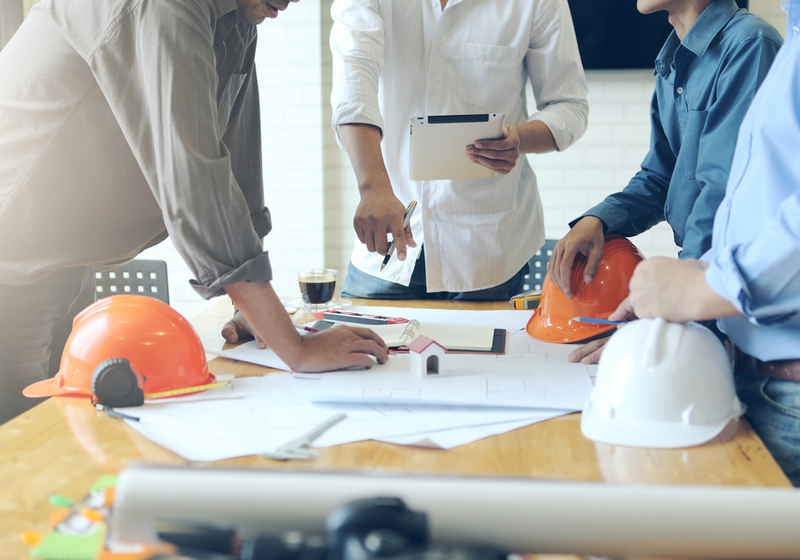 Business objects of team engineers office with construction engineer architect and worker looking building model